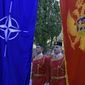 Montenegrin guards of honor stand between NATO, left, and Montenegro flags during ceremony to mark Montenegro&#39;s accession to NATO, in Podgorica, Montenegro, Wednesday, June 7, 2017. Despite opposition from Russia, Montenegro joined NATO on Monday after completing its membership formalities in Washington. (AP Photo/Risto Bozovic)