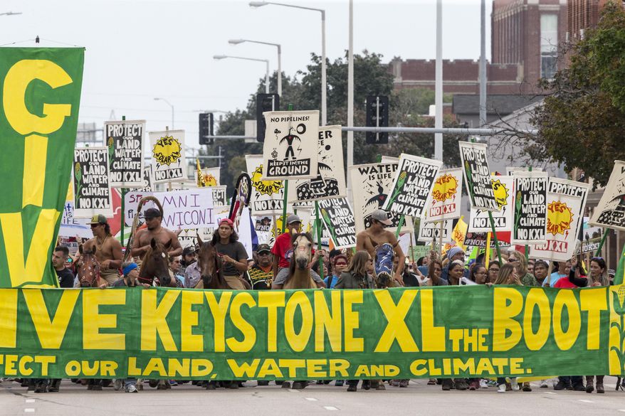 FILE--In this Aug. 6, 2017, file photo, demonstrators against the Keystone XL pipeline march in Lincoln, Neb. Opponents of the proposed oil pipeline from Canada are asking a federal judge to force the U.S. government to turn over emails and other documents related to President Donald Trump's approval of the project. (AP Photo/Nati Harnik, file)