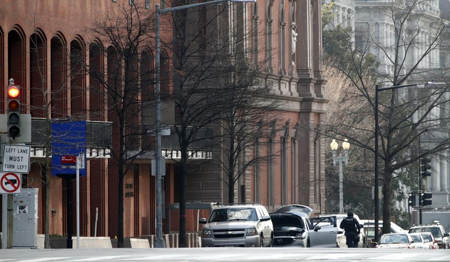 Police are seen searching a suspicious vehicle near the White House, Wednesday, Feb. 21, 2018 in Washington. The Secret Service said the New Executive Office Building, left, was evacuated and a portion of 17th Street had been closed to vehicle traffic. (AP Photo/Jacquelyn Martin)