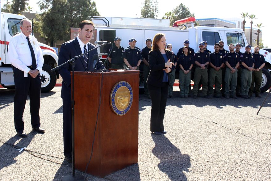 Arizona Gov. Doug Ducey speaks at a news conference on wildfire season as state Forester Jeff Whitney and fire crews look on Thursday, Feb. 22, 2018 in Phoenix, Ariz. Whitney said the upcoming fire season could be one of the worst in his 45 years in firefighting because of the lack of rain across the state's grasslands, chaparral and pine forests. (AP Photo/Bob Christie)