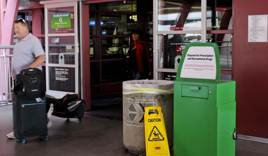 Unidentified travelers exit the airport past a green metal container designed for &amp;quot;Disposal for Prescription and Recreational Drugs,&amp;quot; set outside one of the entrances to McCarran International Airport in Las Vegas, Thursday, Feb. 22, 2018. People catching a flight at the airport can now get rid of prescription and recreational drugs, before entering the Clark County-Department of Aviation-owned property, thanks to the receptacles commonly referred to as &amp;quot;amnesty boxes.&amp;quot; The first of about 20 green metal containers commonly referred to as amnesty boxes were installed earlier this month in response to county officials banning marijuana possession and advertising at the airport last year. (AP Photo/Regina Garcia Cano)