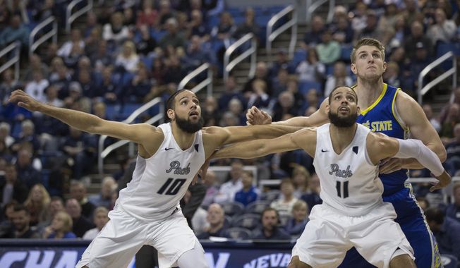 San Jose State&#x27;s Ashtin Chastain, right rear,  and Nevada&#x27;s Caleb Martin (10) and Cody Martin (11) wait for a rebound during the second half of an NCAA college basketball game in Reno, Nev., Wednesday, Feb. 21, 2018. (AP Photo/Tom R. Smedes)