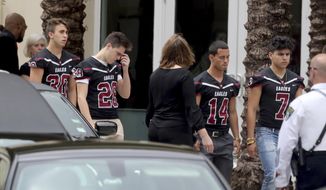 Mourners attend the funeral service for Marjory Stoneman Douglas High School assistant football coach, Aaron Feis. at the Church by the Glades in Coral Springs, Fla., Thursday, Feb. 22. 2018. Football players wearing Stoneman Douglas jerseys carried Feis&#x27; casket into the service at the church where family and friends gathered to remember him as loyal and caring. (Mike Stocker/South Florida Sun-Sentinel via AP)