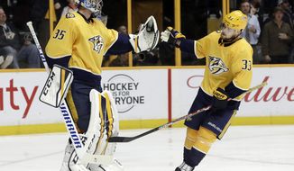 Nashville Predators left wing Viktor Arvidsson (33), of Sweden, is congratulated by goalie Pekka Rinne (35), of Finland, after Arvidsson scored a goal against the San Jose Sharks in the third period of an NHL hockey game Thursday, Feb. 22, 2018, in Nashville, Tenn. (AP Photo/Mark Humphrey)