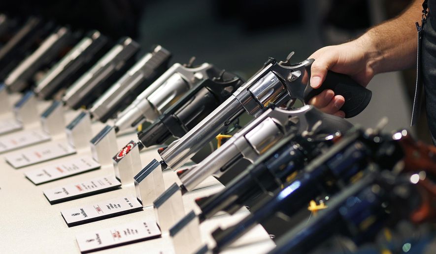 FILE - In this Jan. 19, 2016 file photo, handguns are displayed at a trade show in Las Vegas. With protesters outside the courthouse calling for action, a Nevada judge is due to hear arguments about a voter-approved gun background-check law that has not been enforced since voters passed it in November 2016. The Friday, Feb. 23, 2018, hearing stems from a lawsuit filed in October, just days after a gunman shot into an open-air concert crowd on the Las Vegas Strip, killing 58 people and injuring hundreds. (AP Photo/John Locher, File)