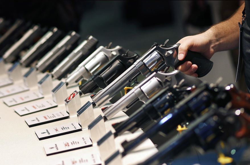 FILE - In this Jan. 19, 2016 file photo, handguns are displayed at a trade show in Las Vegas. With protesters outside the courthouse calling for action, a Nevada judge is due to hear arguments about a voter-approved gun background-check law that has not been enforced since voters passed it in November 2016. The Friday, Feb. 23, 2018, hearing stems from a lawsuit filed in October, just days after a gunman shot into an open-air concert crowd on the Las Vegas Strip, killing 58 people and injuring hundreds. (AP Photo/John Locher, File)