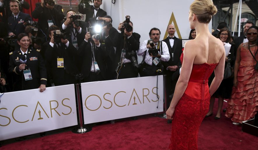 FILE - In this Feb. 22, 2015 file photo, actress Rosamund Pike arrives at the Oscars in Los Angeles. There are two paths on the Oscars red carpet: one for famous people, and one for everyone else. Stanchions and velvet ropes separate the recognizable from the not. Famous folks walk on the side of the carpet closest to the cameras and reporters, and stars often collide or share impromptu carpet greetings. (Photo by Matt Sayles/Invision/AP, File)