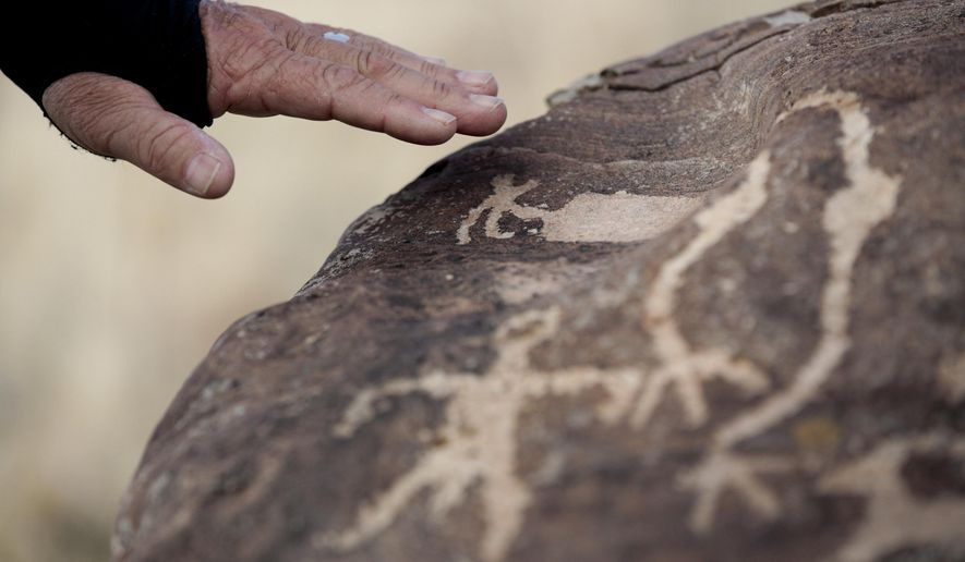 Steven Acerson, the president of the Utah Rock Art Research Association, talks about the rock art on a boulder on Thursday, Feb. 8, 2018, in the West Mountain area of Utah. (Evan Cobb/The Daily Herald via AP)