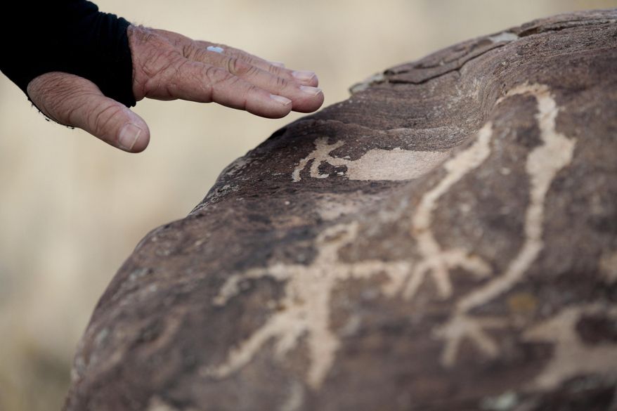 Steven Acerson, the president of the Utah Rock Art Research Association, talks about the rock art on a boulder on Thursday, Feb. 8, 2018, in the West Mountain area of Utah. (Evan Cobb/The Daily Herald via AP)