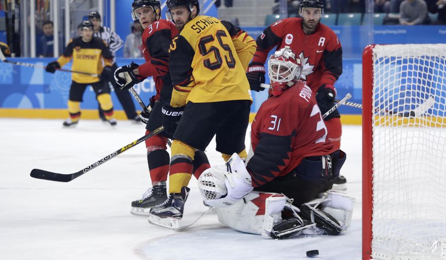 Goalie Kevin Poulin (31), of Canada, looks at the puck shot by Patrick Hager, of Germany, for a goal during the second period of the semifinal round of the men&#39;s hockey game at the 2018 Winter Olympics in Gangneung, South Korea, Friday, Feb. 23, 2018. (AP Photo/Julio Cortez)