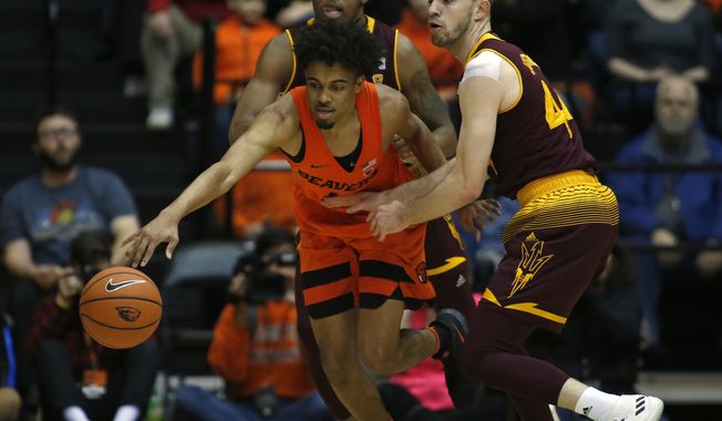 Oregon State&#x27;s Stephen Thompson Jr., center, protects the ball from Arizona State&#x27;s Kimani Lawrence, rear, and Kodi Justice, right, in the first half of an NCAA college basketball game in Corvallis, Ore., Saturday, Feb. 24, 2018. (AP Photo/Timothy J. Gonzalez)