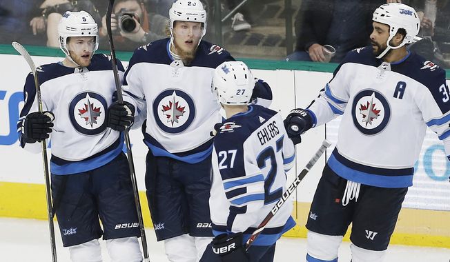Winnipeg Jets forward Patrik Laine (29), second form left, is congratulated by teammates after scoring a goal during the second period of an NHL hockey game against the Dallas Stars, Saturday, Feb. 24, 2018, in Dallas. (AP Photo/Brandon Wade)