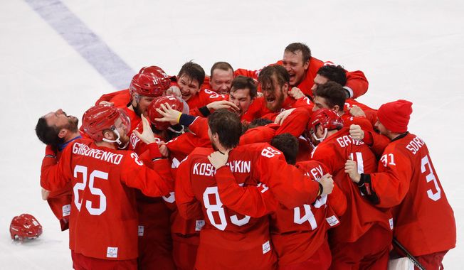 Olympic athletes from Russia celebrate after winning the hockey gold medal against Germany, 4-3, on Sunday. (ASSOCIATED PRESS)