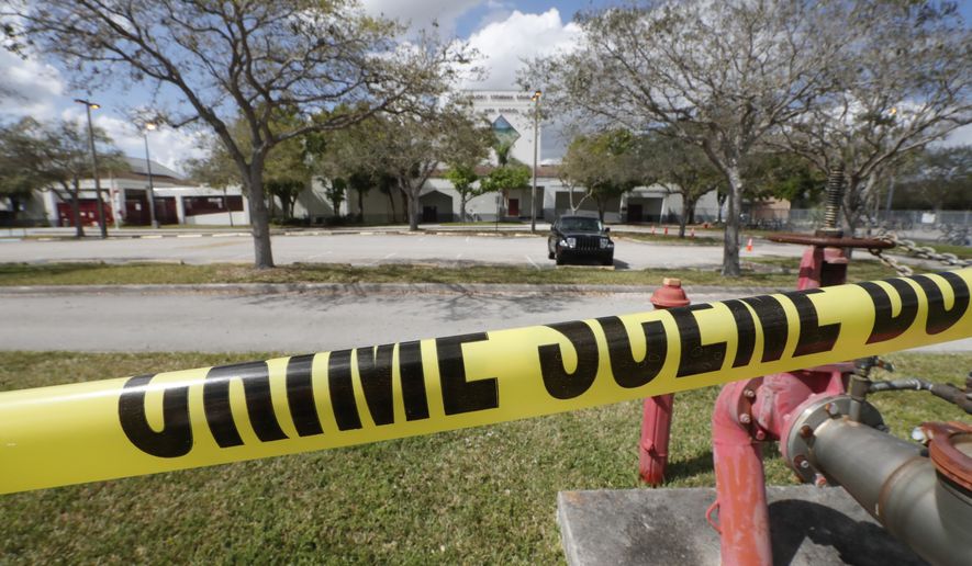 Crime scene tape runs outside Marjory Stoneman Douglas High School in Parkland, Fla., Sunday, Feb. 18, 2018. Authorities opened the streets around the school, which had been closed since a mass shooting on Wednesday. Nikolas Cruz, a former student, was charged with 17 counts of premeditated murder. (AP Photo/Gerald Herbert)