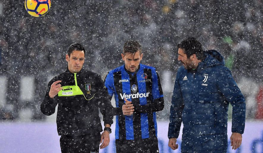 From left, referee Maurizio Mariani, Atalanta&#39;s Rafael Toloi and Juventus goalie Gianluigi Buffon walk on the pitch of the Allianz Stadium in Turin, Italy, Sunday, Feb. 25, 2018. Snowfall has prompted the Serie A match between six-time defending champion Juventus and Atalanta to be postponed. Fans filled the Allianz Stadium shortly before the scheduled kickoff Sunday but when the referee could not roll the ball on the snow-covered pitch, the game was quickly called off. (Alessandro Di Marco/ANSA via AP)