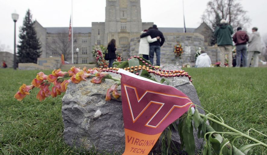 People embrace as they look at a memorial for the shooting victims at Drillfield on the campus of Virginia Tech in Blacksburg, Va., Thursday, April 19, 2007.    (AP Photo/Chuck Burton)
