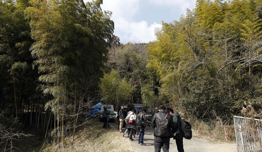 Journalists gather near the site where a body part believed to be of a missing woman was found in Osaka, western Japan Monday, Feb. 26, 2018. Media reports said police last week arrested the suspected man, Yevgeniy Vasilievich Bayraktar, 26, from New York, on suspicion of confining the missing Japanese woman at his lodging in Osaka. Reports said Monday police are investigating his possible link to dismembering and abandoning of her body after finding other body parts. (Yuki Sato/Kyodo News via AP)