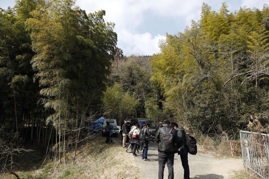 Journalists gather near the site where a body part believed to be of a missing woman was found in Osaka, western Japan Monday, Feb. 26, 2018. Media reports said police last week arrested the suspected man, Yevgeniy Vasilievich Bayraktar, 26, from New York, on suspicion of confining the missing Japanese woman at his lodging in Osaka. Reports said Monday police are investigating his possible link to dismembering and abandoning of her body after finding other body parts. (Yuki Sato/Kyodo News via AP)