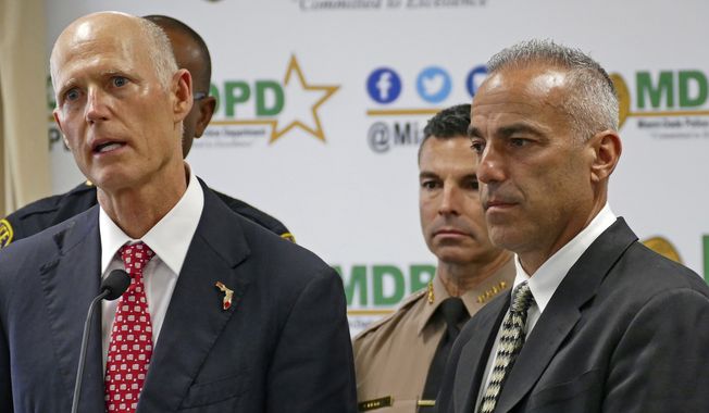 Florida Gov. Rick Scott talks alongside Andrew Pollack, right, whose daughter Meadow was fatally shot in Parkland during press conference at Miami-Dade Police Department in Doral on Tuesday, Feb. 27, 2018. Scott will highlight his action plan to make major changes to help keep Florida students safe, including a $500 million investment in school safety and mental health. (C.M. Guerrero/Miami Herald via AP)