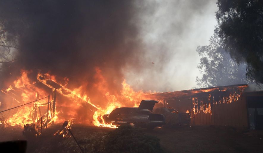 FILE - In this Tuesday, Dec. 5, 2017, file photo a home burns during the Creek Fire in the Lake View Terrace area of Los Angeles. California fire chiefs say that reinforcements were too slow to arrive in last year's ferocious firestorms and asked state lawmakers, Tuesday, Feb. 27, 2018 for $100 million to call in extra firefighters and dispatchers when weather conditions are ripe for a conflagration. (AP Photo/Chris Carlson, file)