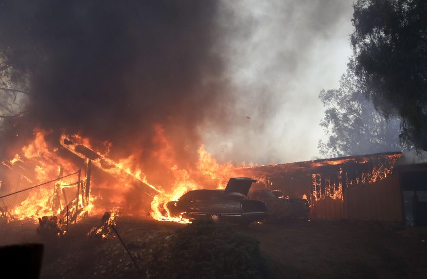 FILE - In this Tuesday, Dec. 5, 2017, file photo a home burns during the Creek Fire in the Lake View Terrace area of Los Angeles. California fire chiefs say that reinforcements were too slow to arrive in last year's ferocious firestorms and asked state lawmakers, Tuesday, Feb. 27, 2018 for $100 million to call in extra firefighters and dispatchers when weather conditions are ripe for a conflagration. (AP Photo/Chris Carlson, file)
