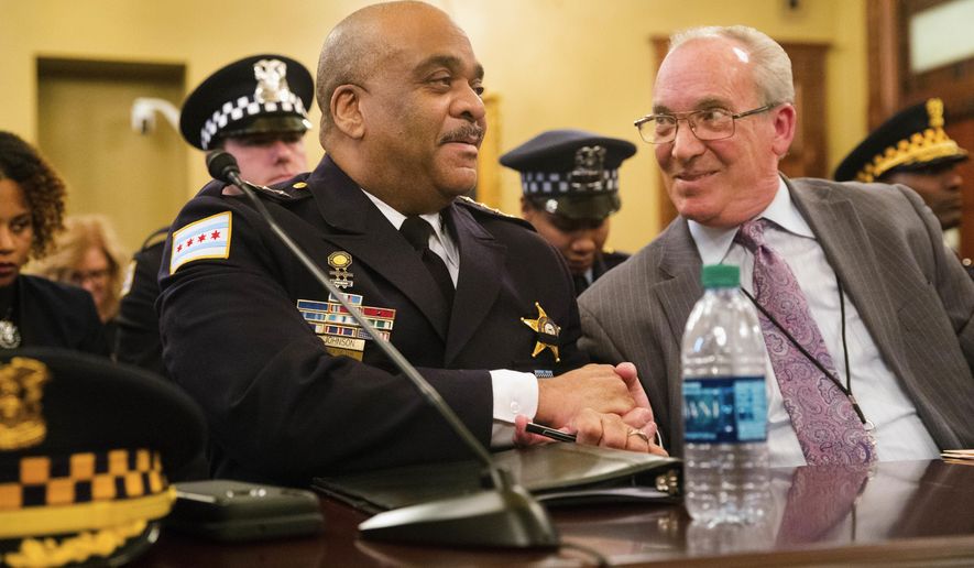Chicago Police Superintendent Eddie Johnson shakes hands with Rep. Daniel J. Burke, D-Chicago, after new gun legislation, part of which is written and named in honor of slain 18th District Commander Paul Bauer, passed a committee in Springfield, Ill., Tuesday, Feb. 27, 2018. (Ted Schurter/The State Journal-Register via AP)