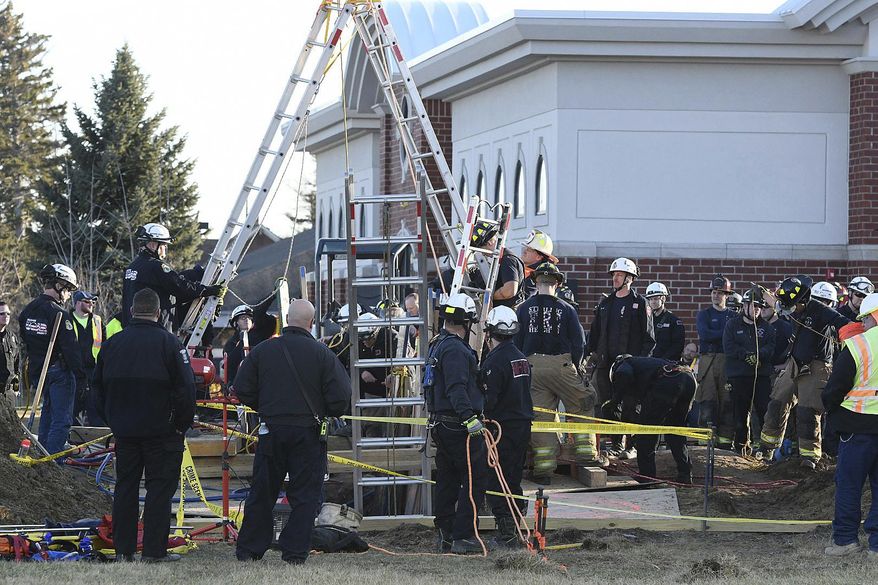 Rescue crews in Sterling Heights, Mich., furiously try to excavate a construction worker Monday, Feb. 26, 2018, after a trench collapsed around him. Authorities say the construction worker has died after being buried in the trench collapse in suburban Detroit. (David Guralnick/Detroit News via AP)/Detroit News via AP)