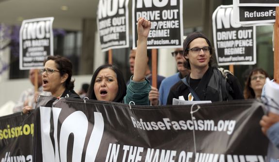 People chant Wednesday, May 10, 2017, as they protest the Tuesday firing of FBI director James Comey by President Donald Trump, outside the downtown Los Angeles federal building. (AP Photo/Reed Saxon)