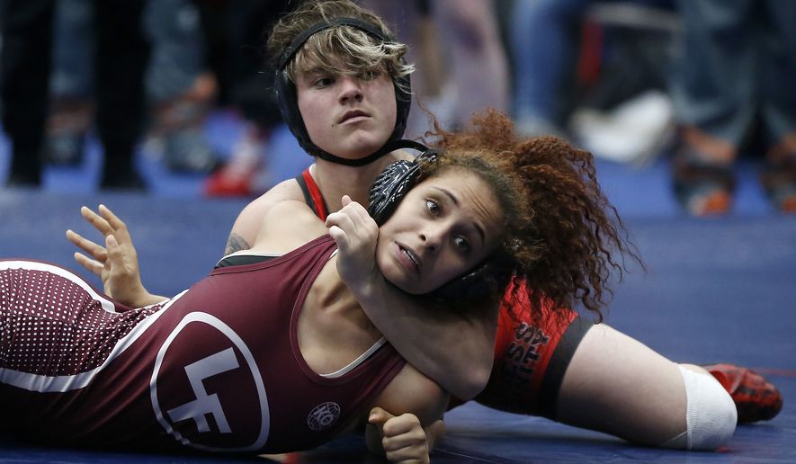 In this Friday, Feb. 16, 2018 photo, Euless Trinity&#39;s Mack Beggs, top, wrestles Lewisville&#39;s Elyse Nelson in the second round of the 110-pound girls division during the 6A Region II wrestling meet at Allen High School in Allen, Texas, Beggs, a senior from Euless Trinity High School near Dallas is transgender and in the process of transitioning from female to male. (Jae S. Lee/The Dallas Morning News via AP)