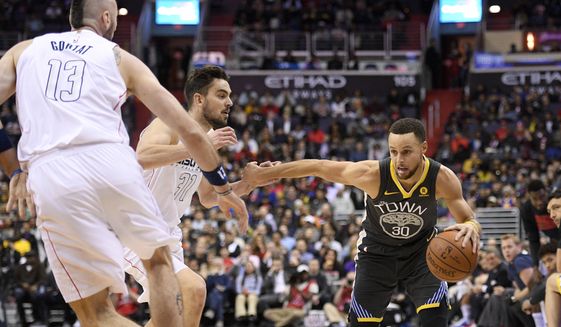 Golden State Warriors guard Stephen Curry (30) drives to the basket against Washington Wizards forward Tomas Satoransky, center, and center Marcin Gortat (13), of Poland, during the first half of an NBA basketball game Wednesday, Feb. 28, 2018, in Washington. (AP Photo/Nick Wass)