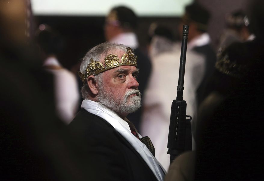A man wears a crown and holds an unloaded weapon at the World Peace and Unification Sanctuary, Wednesday, Feb. 28, 2018, in Newfoundland, Pa. Worshippers clutching AR-15 rifles participated in a commitment ceremony at the Pennsylvania-based church. The event Wednesday morning led a nearby school to cancel classes for the day. The church's leader, the Rev. Sean Moon, said in a prayer that God gave people the right to bear arms. (AP Photo/Jacqueline Larma)
