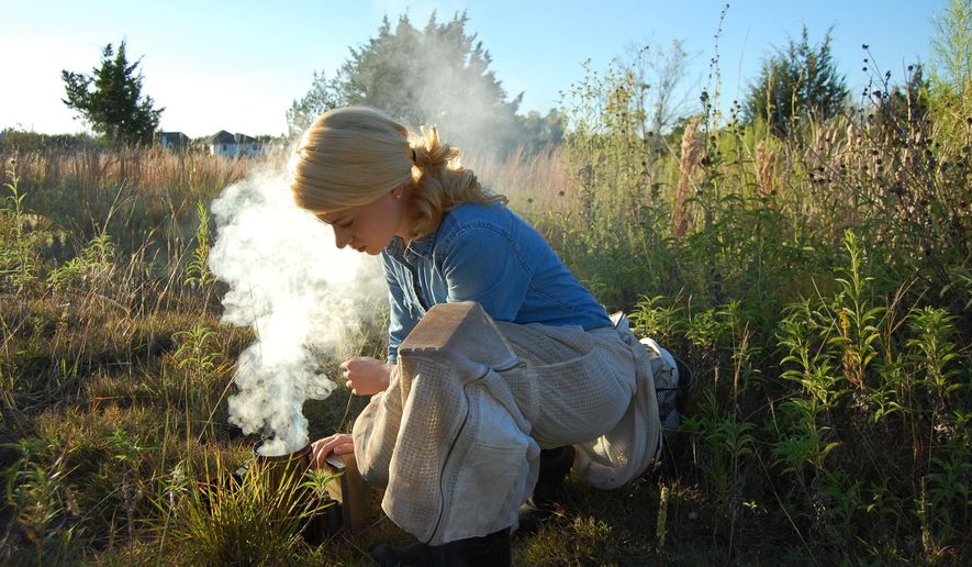 This photo taken Feb. 23, 2018, shows Erika Thompson, owner and founder of Texas Beeworks, igniting her bee smoker in preparation of inspecting the hives. The smoke masks alarm pheromones that bees naturally produce and creates an opportunity for the beekeeper to open the hive and work while the colony s defense response is muted. These are my most well-behaved hives, Thompson said. Their mood can depend on the day, but for the most part they are usually pretty calm. (Connor Brown /Austin American-Statesman via AP)