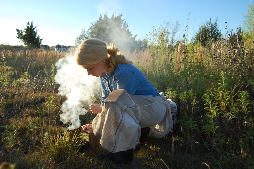 This photo taken Feb. 23, 2018, shows Erika Thompson, owner and founder of Texas Beeworks, igniting her bee smoker in preparation of inspecting the hives. The smoke masks alarm pheromones that bees naturally produce and creates an opportunity for the beekeeper to open the hive and work while the colony s defense response is muted. These are my most well-behaved hives, Thompson said. Their mood can depend on the day, but for the most part they are usually pretty calm. (Connor Brown /Austin American-Statesman via AP)