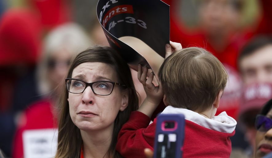 Holly Blastic, 37, holds her son Henry Schroetlin, 5, during a rally outside the State Capitol ahead of the House's plan to hold votes on several gun control proposals Wednesday Feb. 28, 2018, in Springfield, Ill. (Armando L. Sanchez/Chicago Tribune)