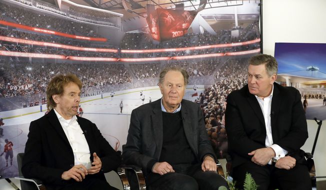 Hollywood producer Jerry Bruckheimer, billionaire David Bonderman, and Oak View Group Chief Executive Tim Leiweke, from left, take part in a TV interview Wednesday, Feb. 28, 2018, in Seattle. The group trying to bring NHL hockey to Seattle says it hopes to hear in June whether its application for an expansion team succeeds, and is launching a season-ticket deposit drive Thursday meant to prove fan interest in a hockey franchise. (AP Photo/Ted S. Warren)