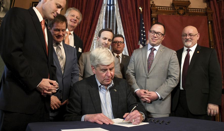 Gov. Rick Snyder signs legislation to keep intact and raise Michigan’s personal income tax exemption during a ceremony in Lansing, Mich., Wednesday, Feb 28, 2018. (Dale G.Young/Detroit News via AP)