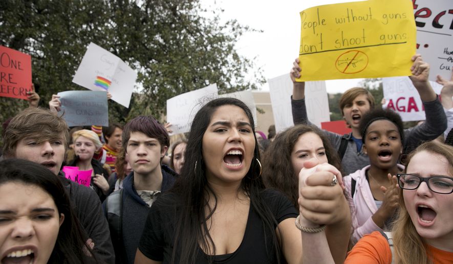 Madison Flores, 17, middle, participates in a walkout and demonstration for gun control at Anderson High School in Austin, Texas, on Friday Feb. 23, 2018. (Jay Janner/Austin American-Statesman via AP)