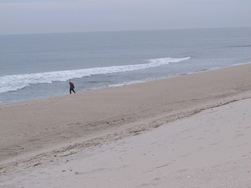 A man walks on the newly widened beach in Mantoloking, N.J. Thursday, March 1, 2018, hours before a powerful coastal storm was due to hit the area. Federal officials say there's no guarantee that sand washed away from the as-yet unfinished project over the next two days will be replaced. (AP Photo/Wayne Parry)