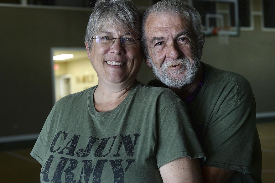 In this Feb. 15, 2018 photo, Patty and Richard Gibbs, who both came to Hamshire, Texas in the aftermath of Tropical Storm Harvey to volunteer, pose for a photo. Somewhere between gutting houses and hauling off debris after Tropical Storm Harvey, the two Cajun Army volunteers fell in love in Texas. (Kim Brent/The Beaumont Enterprise via AP)
