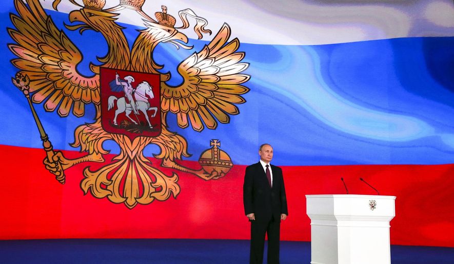 Russian President Vladimir Putin stands after giving his annual state of the nation address in Manezh in Moscow, Russia, Thursday, March 1, 2018. Putin set a slew of ambitious economic goals, vowing to boost living standards, improve health care and education and build modern infrastructure in a state-of-the-nation address. (Mikhail Klimentyev, Sputnik, Kremlin Pool Photo via AP)