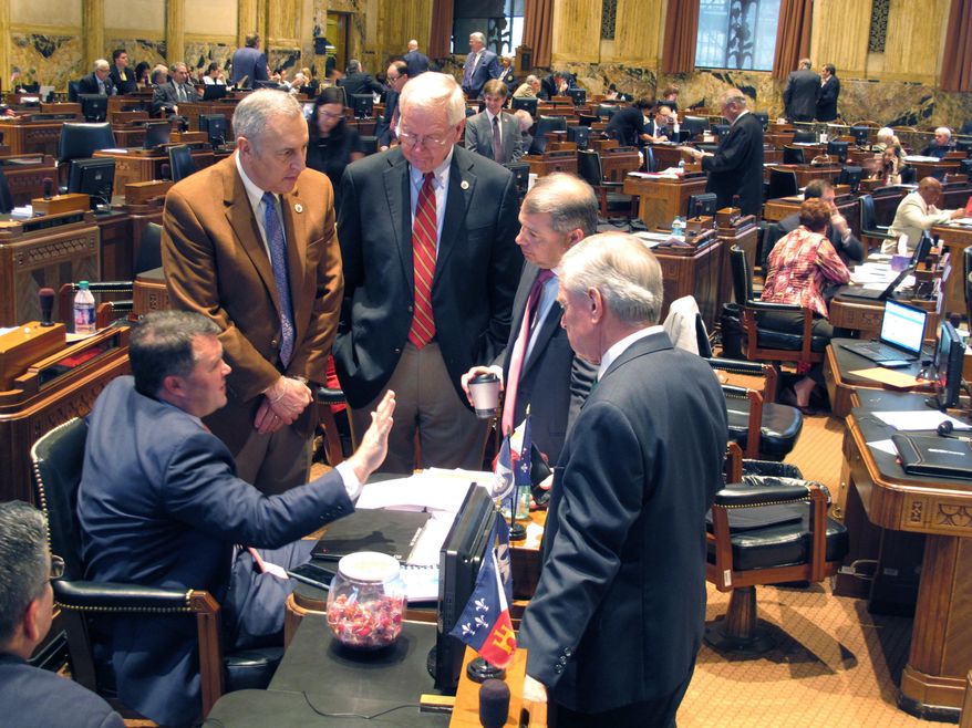 Rep. Stephen Dwight, R-Lake Charles, seated left, speaks with from left to right, Reps. Mark Abraham, R-Lake Charles; Frank Hoffmann, R-West Monroe; Chad Brown, D-Plaquemine; and Mike Danahay, D-Sulphur, on the House floor, Thursday, March 1, 2018, in Baton Rouge, La. Dwight is the sponsor of the main sales tax bill in the Louisiana Legislature's tax debate. (AP Photo/Melinda Deslatte)