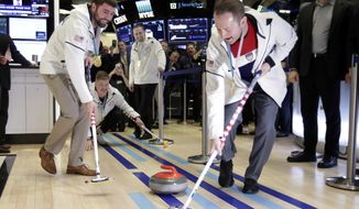 U.S. Olympic gold medalists in curling John Landsteiner, Matt Hamilton, Joe Polo and Tyler George, left to right, demonstrate their sport on the floor of the New York Stock Exchange, before ringing the opening bell, Friday, March 2, 2018. (AP Photo/Richard Drew)