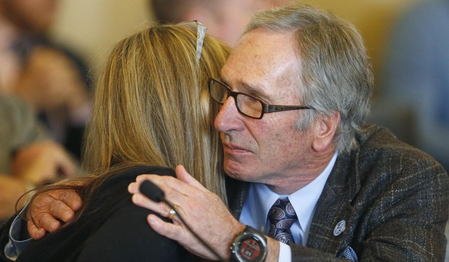 Republican Rep. Gage Froerer hugs Christine Stenquist after testifying during a hearing Wednesday, Feb. 21, 2018, at the Utah State Capitol, in Salt Lake City. A Republican state lawmaker plan to repeal the death penalty in deep-red Utah cleared its first test Wednesday, winning approval from a legislative committee as Utah's GOP governor said he's open to signing the ban. Stenquist relayed her personal experience with the brutal murder of her sister and the family's decision not to pursue the death penalty. (AP Photo/Rick Bowmer)