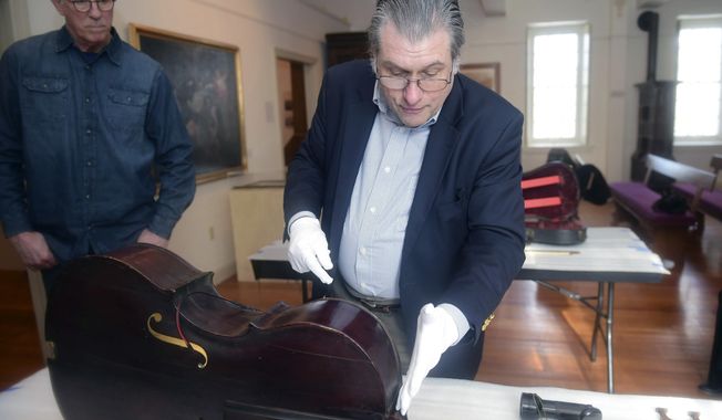 In this Feb. 6, 2018 photo, a cello, built by John Antes, a Moravian Missionary, purchased by Tom Riddle is examined for authenticity at the Moravian Historical Society by Phillip J. Kass in Nazareth, Pa. It is thought that the cello is among the first bowstring instruments made in America. A violin and viola where also examined as all three are thought to have been made by Antes. (Amy Herzog/The Morning Call via AP)