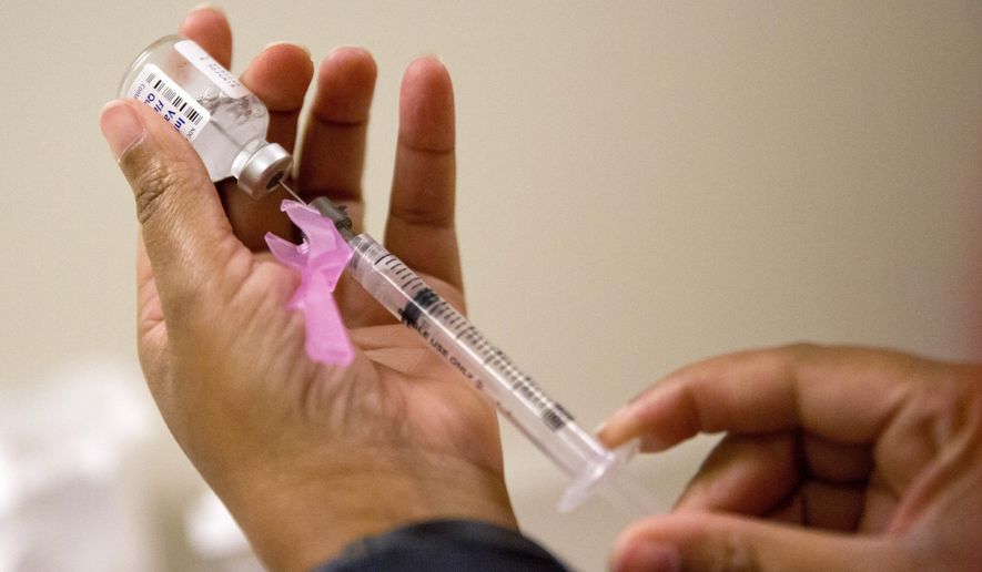FILE - In this Feb. 7, 2018 file photo, a nurse prepares a flu shot at the Salvation Army in Atlanta. The nation’s nasty flu season has been fading for two weeks now, and health officials now feel confident the worst is over. The Centers for Disease Control and Prevention said the season apparently peaked in early February, when 1 of every 13 visits to the doctor were for fever, cough and other symptoms of the flu. That intensity level was among the highest seen in a decade. But CDC officials on Friday, March 2, said it's been falling since then, and last week dropped to 1 in 20. (AP Photo/David Goldman, File)