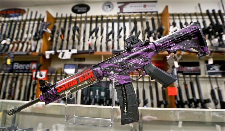 A Smith &amp; Wesson M&amp;P 15-22 Muddy Girl Sport rifle chambered in .22 LR is shown in front of a rack of other rifles at Duke&#x27;s Sport Shop in New Castle, Pa. on Thursday, March 1, 2018. (AP Photo/Keith Srakocic)