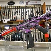 A Smith &amp; Wesson M&amp;P 15-22 Muddy Girl Sport rifle chambered in .22 LR is shown in front of a rack of other rifles at Duke&#x27;s Sport Shop in New Castle, Pa. on Thursday, March 1, 2018. (AP Photo/Keith Srakocic)