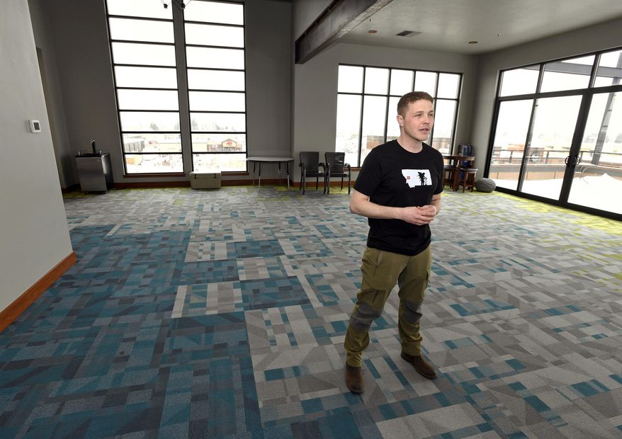 In this Feb. 23, 2018, photo, Eric Siegfried, founder and president of onXmaps, stands in the top floor of the mapping technology company's new building in Missoula, Mont. By using a mobile phone’s built-in Global Positioning System that relies on satellites, onXmaps aims to give users a detailed map, including public and private ownership boundaries, of where they are anywhere in the U.S. That’s something not even the largest tech companies like Apple and Google have done, as they've focused mainly on urban areas. But there's a huge market for better GPS-based maps in America's vast uninhabited public lands. (Tom Bauer/The Missoulian via AP)