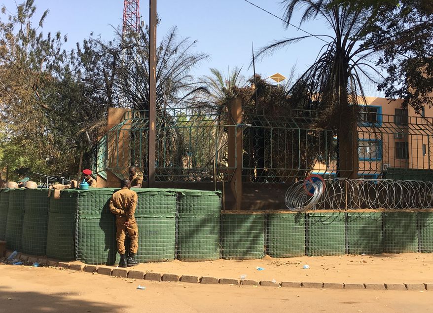 CORRECTING DATE TO MARCH 3 - Security forces outside the General Staff of the Armed Forces building in central Ouagadougou, Burkina Faso, Saturday March 3, 2018. The markets returned to near normal Saturday, after Islamic extremists struck the French Embassy and army headquarters Friday in simultaneous attacks of gunfire and explosives, killing eight people and wounding more than 80 others. (AP Photo/ Ludivine Laniepce)