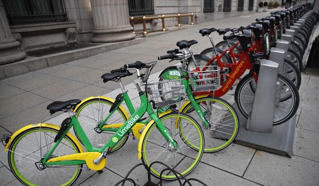 In this Feb. 13, 2018, file photo, two dockless LimeBike&#x27;s share the sidewalk with others from Washington, D.C.&#x27;s docked share program called Capital Bikeshare in Washington. (AP Photo/Jacquelyn Martin) ** FILE **